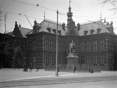 811553 Gezicht op het Academiegebouw (Domplein 29) te Utrecht, in de sneeuw, met op de voorgrond het standbeeld Jan van ...